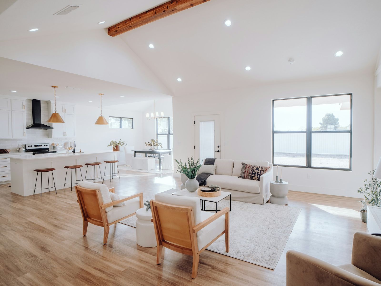 Vaulted living area with a timber beam and warm wood floors, illustrative stock photo