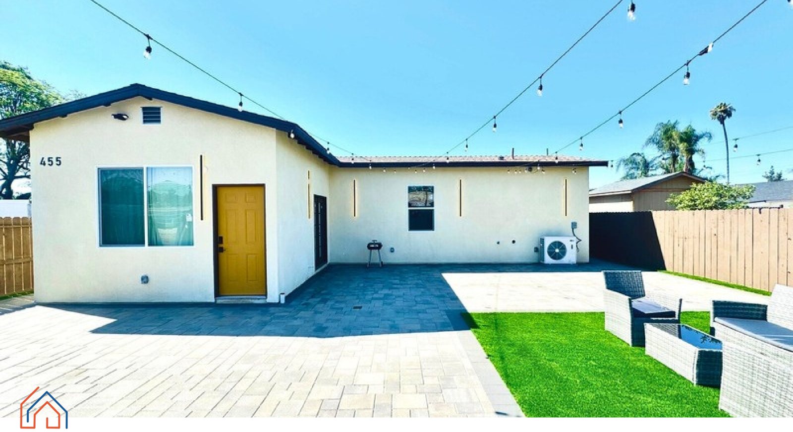 The rear elevation of a real detached ADU, with string lighting over a paved patio