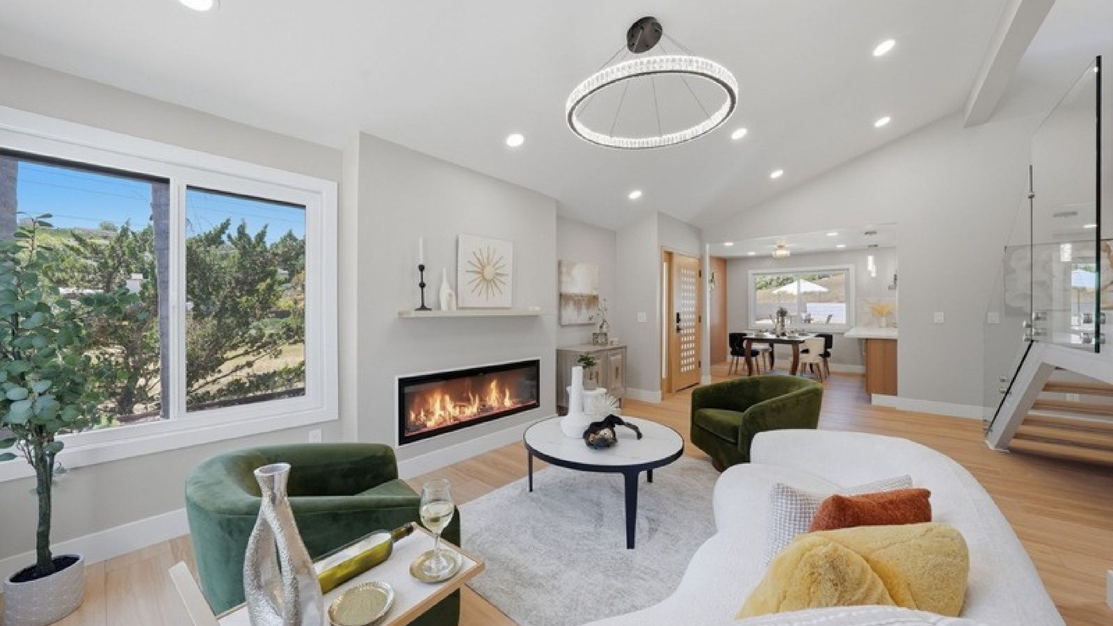 An open-plan living room with a fireplace and vaulted ceiling