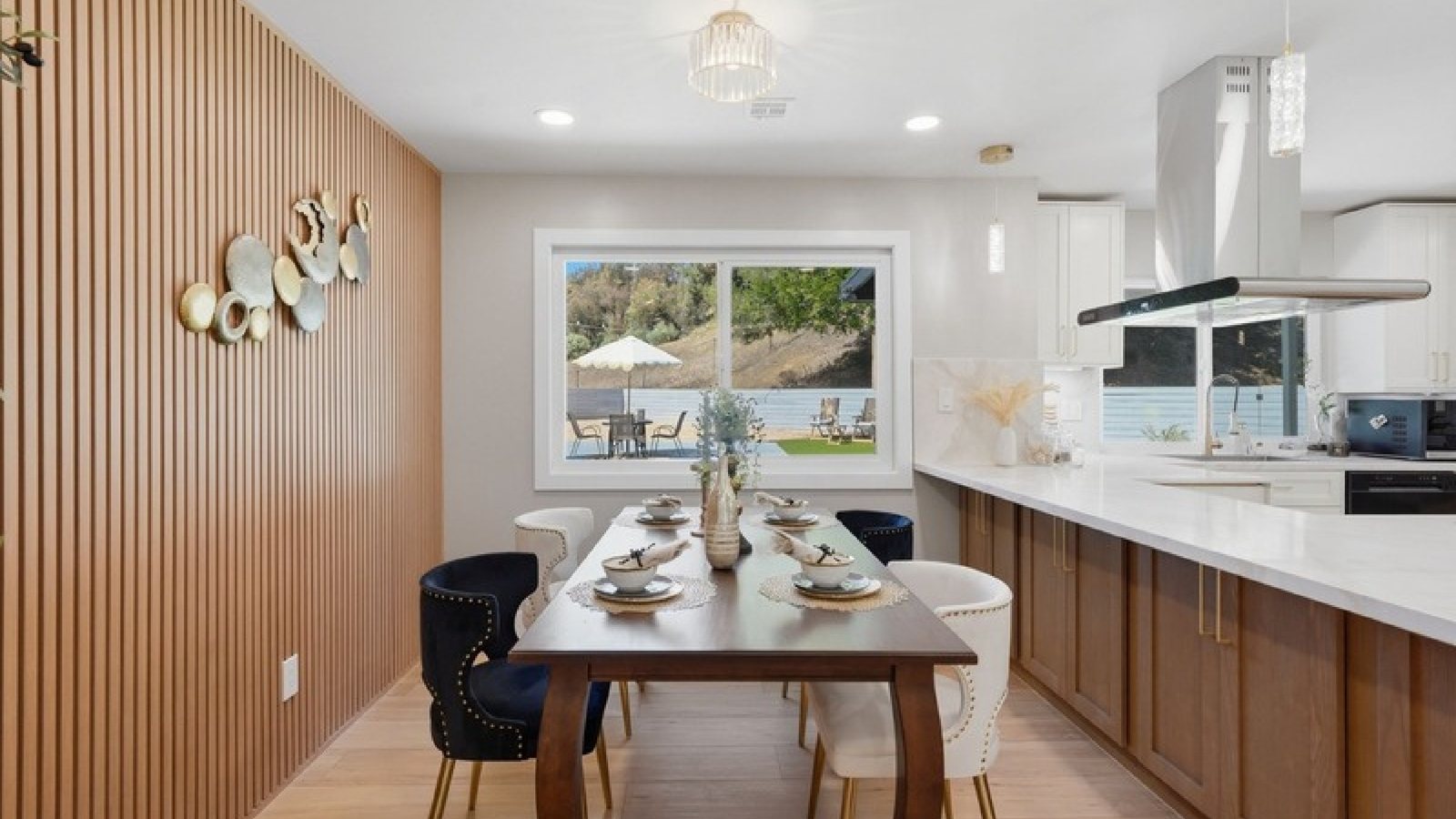 A kitchen and dining area with a timber-slat accent wall